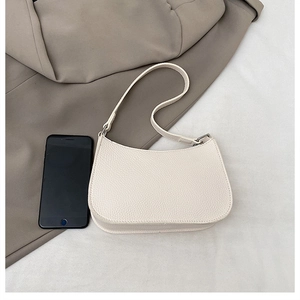 Cream lychee leather crescent bag shown with a smartphone for size reference