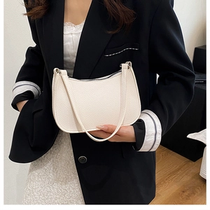 Close-up of white lychee pattern leather baguette bag with premium texture and metal zipper