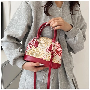 Detail of red and white shell bag with floral embroidery and golden metal hardware