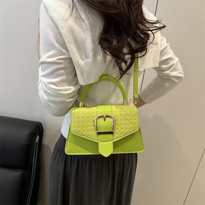 Neongrüne kleine quadratische Tasche mit Krokostruktur und Goldschnalle am Model