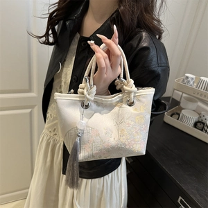 New Chinese bucket bag with floral embroidery and rope handle shown on a model