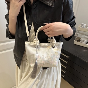 New Chinese style bucket bag with floral embroidery and tassel on white textured fabric