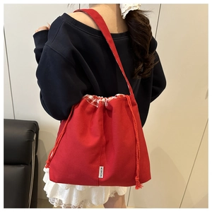 Détail du sac fourre-tout en toile rouge avec cordon et doublure à carreaux rouges