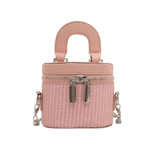 Pink mini box-shaped woven bag with dual zippers and silver chain strap on white background