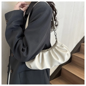Detailed side view of off-white pleated shoulder bag showing texture and dimensions