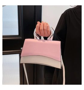 Close-up of pink and white handbag featuring a unique silver metallic irregular handle