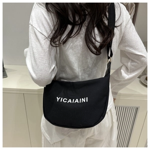 Model wearing a large black nylon crossbody bag with white YICAIAINI text print