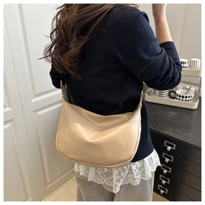 Detailed view of beige soft PU hobo bag with Fashion & Bag print on shoulder of a model