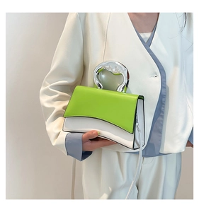 Detail of green and white color-block crossbody bag with unique silver handle