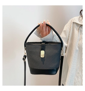 Detail of black leather and grey fabric bucket bag with a golden twist lock closure