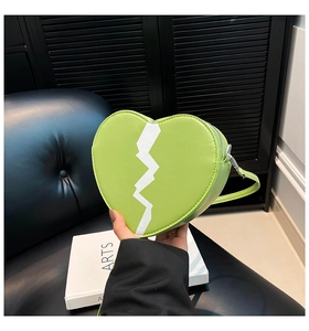 Détail du sac bandoulière vert en forme de cœur avec couture en zigzag sur cuir PU souple