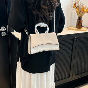 Chic cream crossbody bag with silver heart metal handle and elegant minimalist flap design