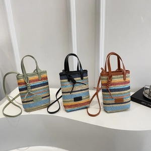 Three colorful striped woven mini shoulder bags with FASHION label on white display stands