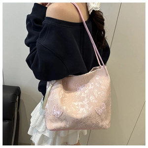 Detailed view of pink butterfly embroidery and lace texture on a stylish shoulder bag
