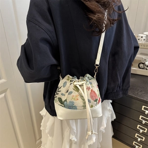 Floral tapestry bucket bag with white leather trim and gold hardware in casual style