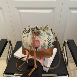 Retro floral jacquard weave bucket bag with brown leather trim and drawstring closure
