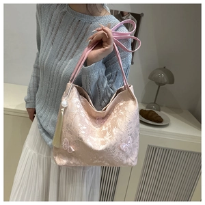 Pink lace hobo bag featuring 3D butterfly appliques and a long beaded tassel detail