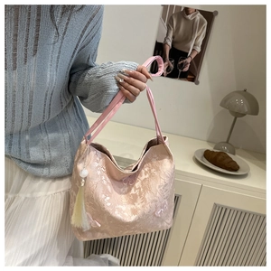 Detail of pink floral jacquard tote with beaded tassels and elegant top handle