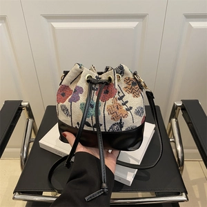 Handheld vintage jacquard floral drawstring bucket bag with black leather straps and trim