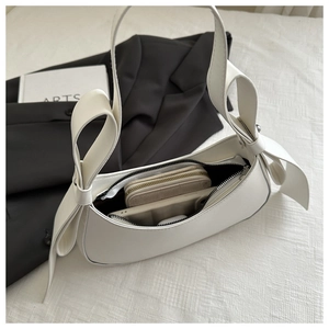 White crescent underarm bag interior showing storage space for phone and wallet