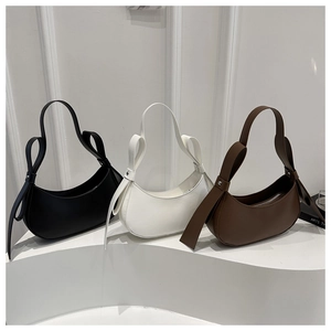 Minimalist half-moon underarm bags in black, white, and brown with decorative side straps