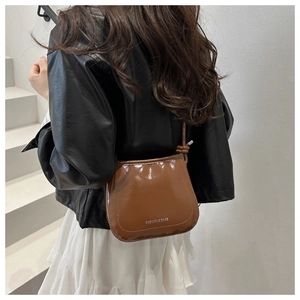 Dettaglio di una borsa a tracolla in pelle lucida marrone con logo Fashion & Bags