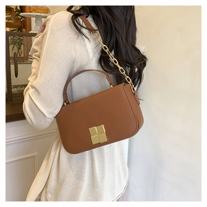 Vue latérale arrière d'un sac bandoulière en cuir marron avec boucle dorée sur un mannequin
