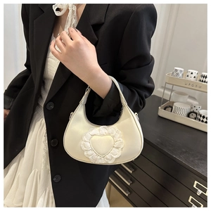 Détail du sac à main blanc semi-circulaire avec cœur en dentelle et finition en similicuir