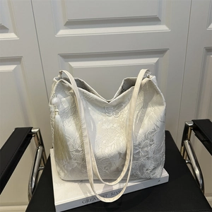 Elegant ivory tote bag with delicate lace butterfly embroidery and silk tassel detail