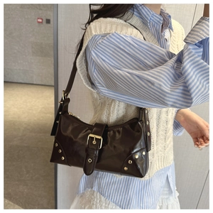 Borsa sottobraccio vintage in pelle marrone con borchie e fibbia su camicia blu