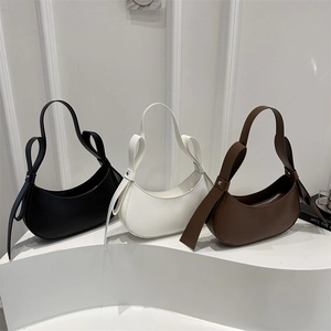 Minimalist half-moon underarm bag with bow detail in black, white, and brown colors