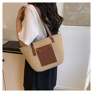 Detail showing woven texture and brown leather pocket on the summer straw tote bag