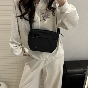 Minimalist black nylon crossbody bag with zipper pocket and adjustable strap for women