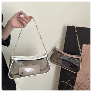 Detail of transparent PVC shoulder bags with white and black piping and gold chains