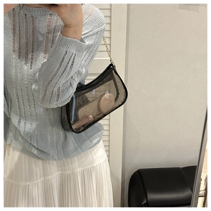 Mirror selfie showing the fit of the black transparent PVC shoulder bag with gold chain