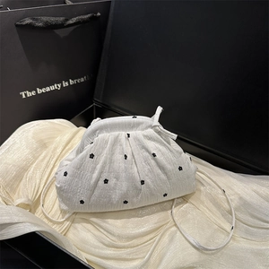 White puffy cloud bag with black flower embroidery and slender shoulder strap