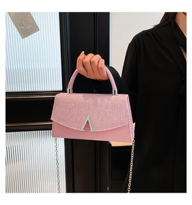 Sac à main rose en cuir avec paillettes brillantes et fermoir métallique en forme d'A