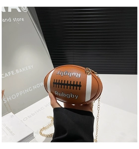 Detailed shot of creative rugby-shaped brown leather mini chain bag held by model