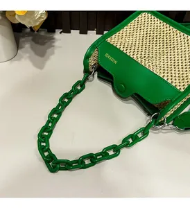 Macro view of woven straw texture with green leather edges and golden logo detail