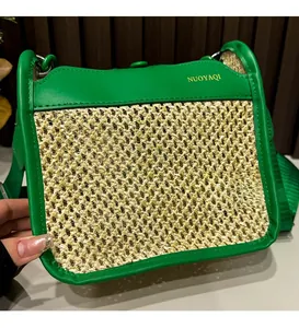Close-up of green leather and straw woven texture on a stylish crossbody bag
