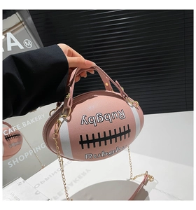 Macro detail of pink rugby shaped handbag with white Rubgby lettering and metal chain