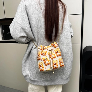 Détail du sac seau à motifs d'oursons avec une bandoulière en chaîne dorée