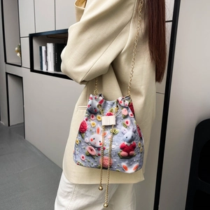 Détail de broderie lapin et fleurs sur sac seau bleu clair avec bandoulière en chaîne