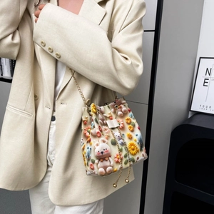 Détail du sac seau au crochet avec fleurs tricotées 3D, ours et bandoulière dorée