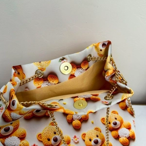 Détail du sac seau en toile avec motif ours, fermoir magnétique doré et bandoulière