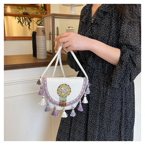 Detail of white woven saddle bag featuring purple fringe tassels and ethnic embroidery