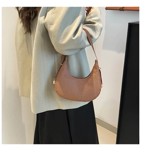 Close-up of brown woven leather hobo bag with sleek shoulder strap and gold buckle detail
