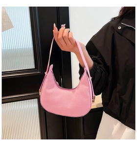Detailed close-up of a pink corduroy hobo bag with gold hardware on a dark backdrop