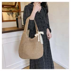 Détail du sac cabas en paille tissé à la main avec un nœud en dentelle blanche élégant