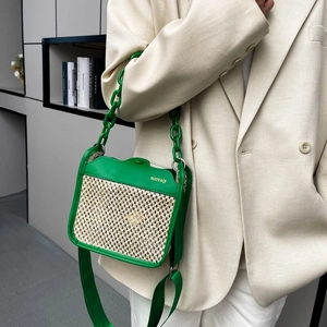 Green leather trim straw crossbody bag with thick resin chain strap and woven panel